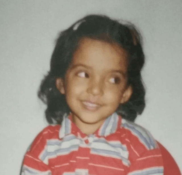 Shivangi as a young child in a red, white, and blue striped polo with a gentle sideways smile