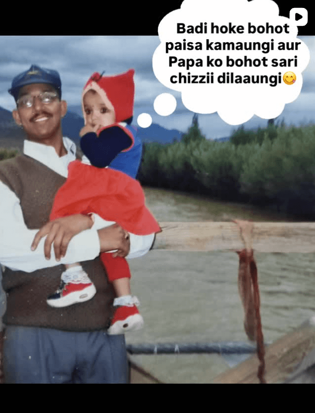 Young Shivangi in a red hood held by her father by a river