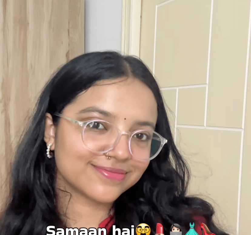 Shivangi in clear round glasses with a bindi, gold nose ring, pearl hoops, and pink lipstick, in a birthday reel about gifts